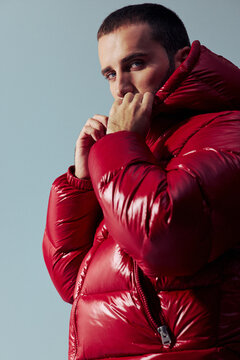 Man in Red Jacket Poses Against Plain Background Indoors