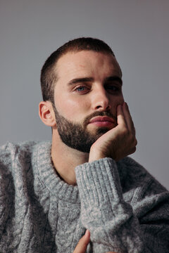 Man Thinking With Hand on Face in Studio Setting