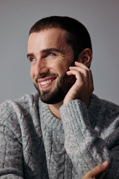 Man Smiles While Resting His Hand on His Face Indoors