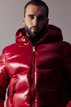 Man Wearing a Red Puffer Jacket With a Hood Indoors