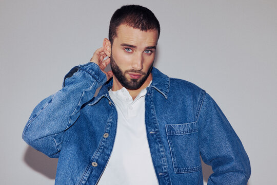 Man in Denim Jacket Posing Against Plain Background