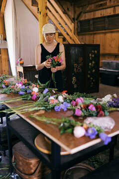 florist worker arranging bulk order of bouquets in summer 