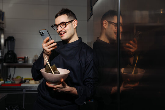 Chef Checking Phone While Holding Bowl of Ramen