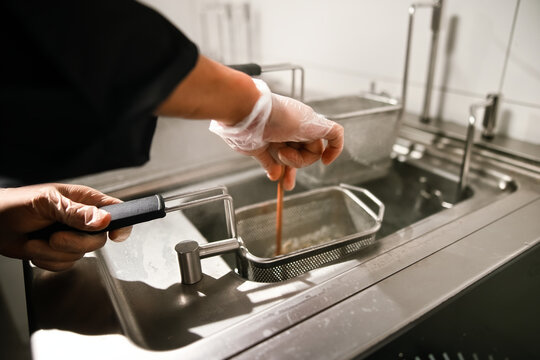Chef Using Deep Fryer Baskets in Commercial Kitchen
