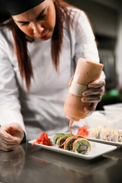Sushi Chef Plating Rolls and Drizzling Sauce