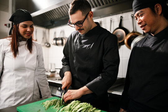 Restaurant Chefs Collaborating While Preparing Fresh Vegetables