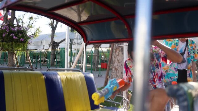 Young Asian Couple Celebrating Songkran Festival with Water Guns in Tuk Tuk