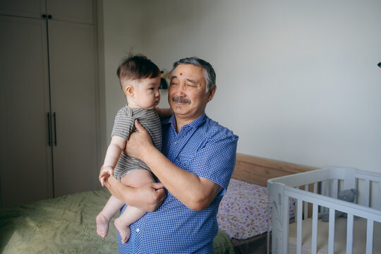 Grandfather Holding Baby at Home
