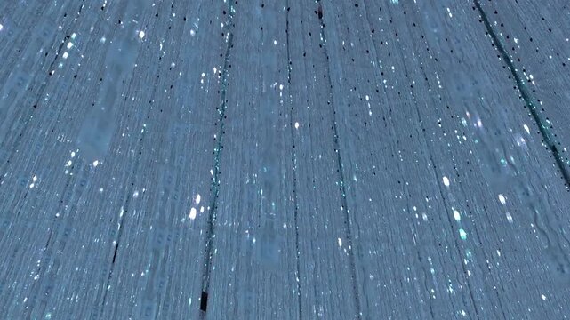 Blue wooden plank background with snowfall winter atmosphere creating peaceful serene mood for holiday celebration, seasonal greeting card rustic timber texture, rain drop falling dark grey grain