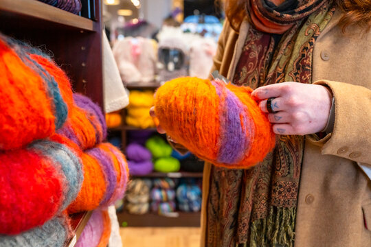 Warm Colors Fill the Yarn Shop as a Person Selects a Skein
