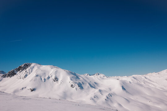 Snow-covered Mountains Under Clear Blue Sky in Winter Season