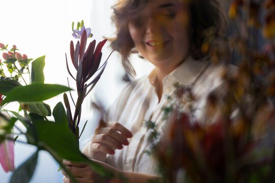 Smiling Woman Arranging Fresh Flowers