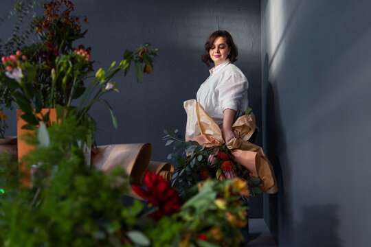 Florist Woman Holding Large Wrapped Bouquet in Studio