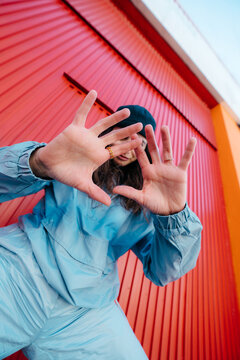 Low angle portrait of urban woman showing hands