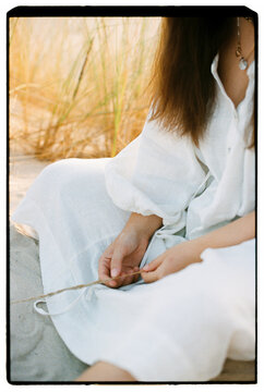 Woman hands holding dry grass in sand dunes