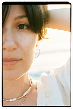 Closeup freckled woman face in golden sunlight