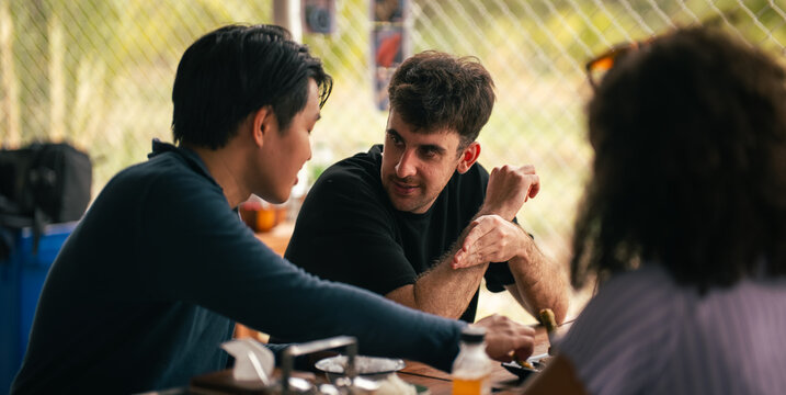 Diverse friends enjoying lunch outdoors, talking and sharing a meal