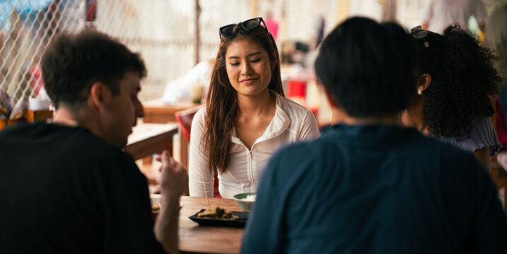 Group of friends eating together at a casual Bangkok restaurant