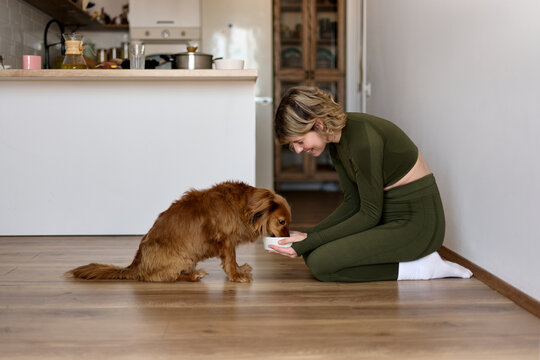 Woman Hugging Her Dog on Yoga Mat at Home