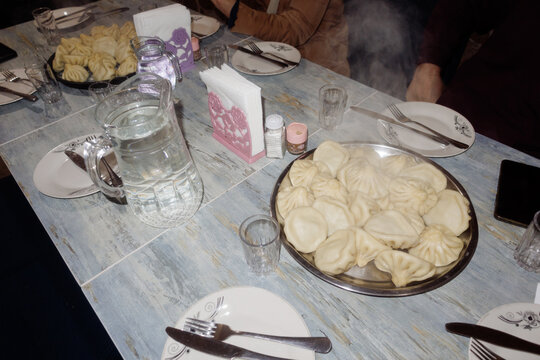 two large dishes with khinkali on the table