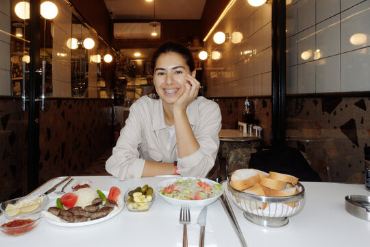Portrait of a young woman at a table.