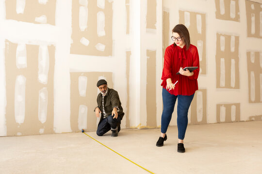 Interior designer and architect taking measurements 