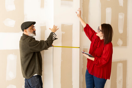 Interior designer and constructor taking measurements 