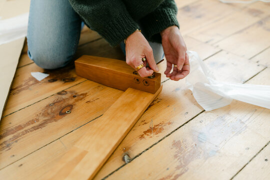 Anonymous woman putting bed together 