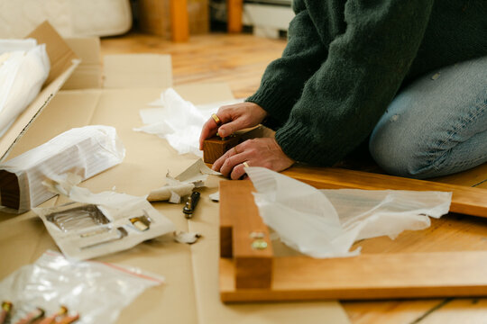 Anonymous woman putting bed together 