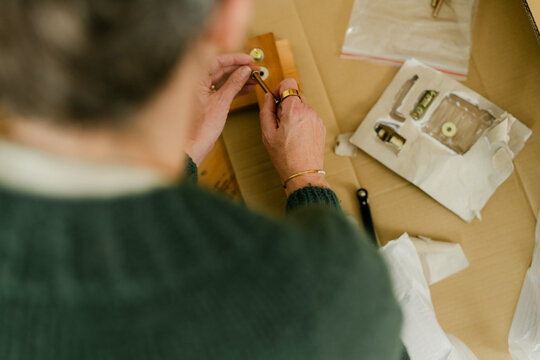 middle aged woman putting bed together 