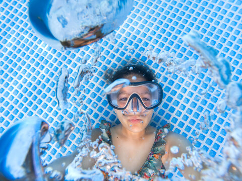 Underwater self portrait of a girl blowing bubbles.
