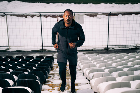 Black Man Jogging Up Stadium Stairs in Winter