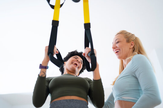 Women workout together using suspension straps