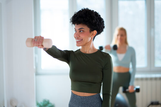 Women exercise with weights in a gym studio