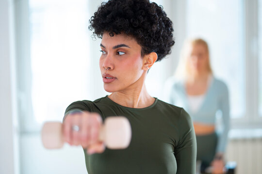 Woman lifting dumbbell in workout session indoors