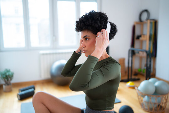 Woman exercising with headphones in a gym setting