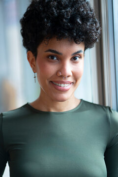 Smiling person in casual setting near window