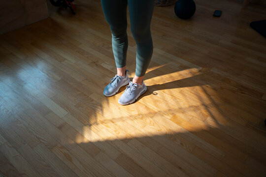 Person stands in gym with bright sunlight on floor