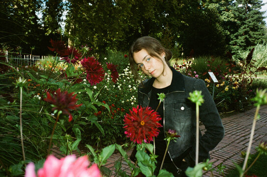 Young woman standing among flowers in garden