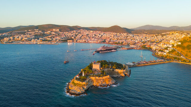 Kusadasi, Turkey. Aerial view of the historic Pigeon Island Fortress at sunset. The shot captures the Pirate Castle built by Barbarossa, glowing in the evening light.. Aerial View