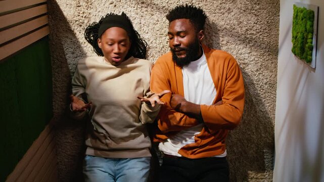 Top down view of black young people fighting and yelling in a dark hallway, heated argument with rage and aggressive behavior. Domestic life conflict with emotional stress, toxic relationship.