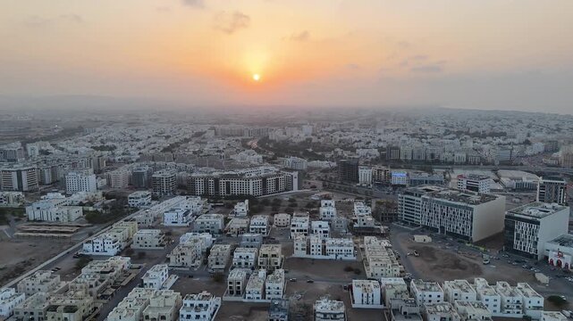 Muscat, Oman. Aerial drone view at sunset of the capital of Oman. Flight over the Mohammed Al Amin Mosque at sunrise or sunset. Flight over the sleeping city in the morning light.