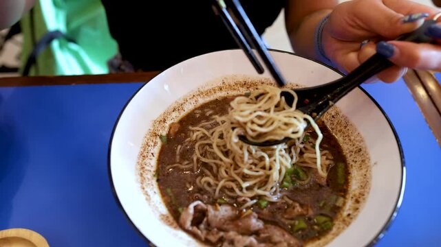 Person Eating Thai Boat Noodles with Pork and Rice Vermicelli
