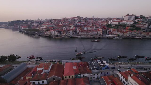 Douro River with Ribeira district Igreja dos Clerigos tower and Teleferico de Gaia in Porto municipality Porto district Norte, Portugal with rabelo boats along Av de Diogo Leite, backwards dorne orbit