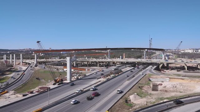 Major construction slows traffic at Interstate I-10 where it intersects local San Antonio highway Loop 1604 as they build an overpass to effortlessly connect the two Texas road systems.