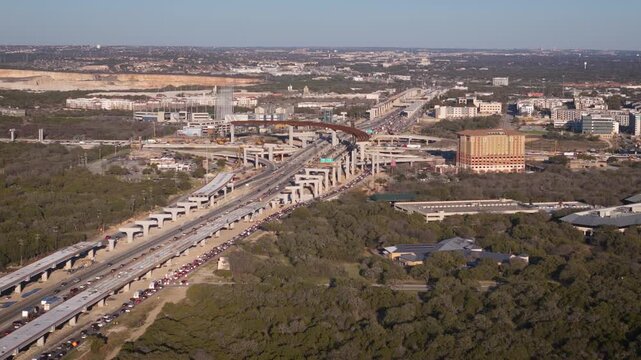 Major construction slows traffic at Interstate I-10 where it intersects local San Antonio highway Loop 1604 as they build an overpass to effortlessly connect the two Texas road systems.