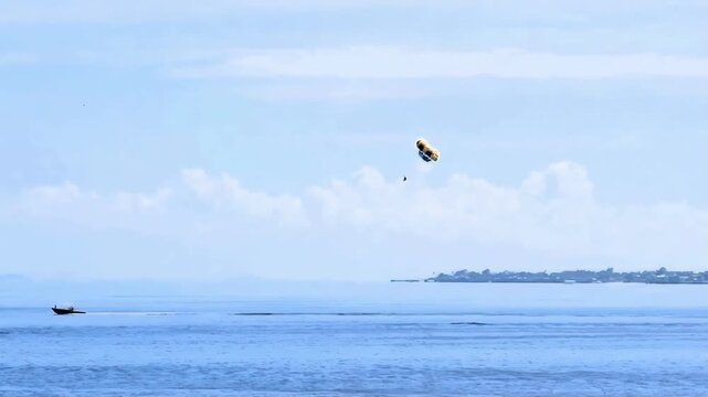 A vacationer enjoying a parasail ride on Hilutungaan Channel is a typical sight at a resort in Lapulapu City, Phillippines. This body of water is located between Mactan Island and Olango Island.