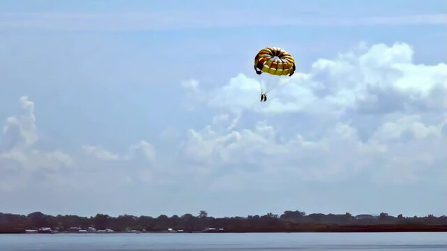 A vacationer at a resort in Lapulapu City, Phillippines, enjoys the thrill of a parasail ride above Hilutungaan Channel, between Mactan Island and Olango Island.