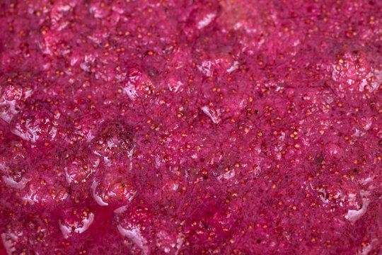 Pureed wild strawberries granular jam texture with sugar crystals and pulpy strands, close macro study for preserve production, recipe photography and food manufacturing concepts
