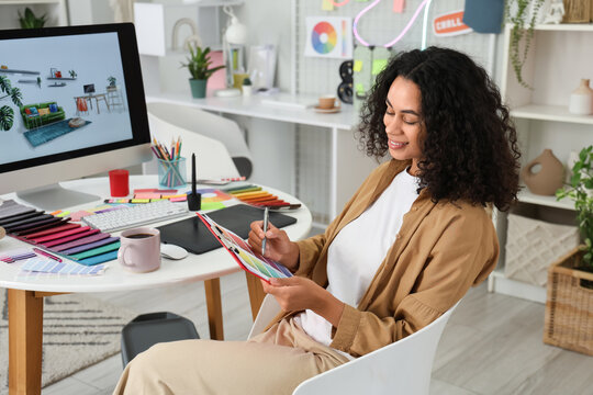 Female African-American interior designer with color palette in office